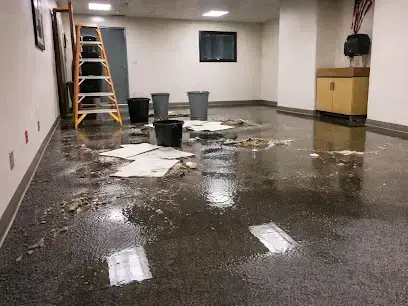 Commercial room with standing water, buckets and a ladder near Hanahan shops