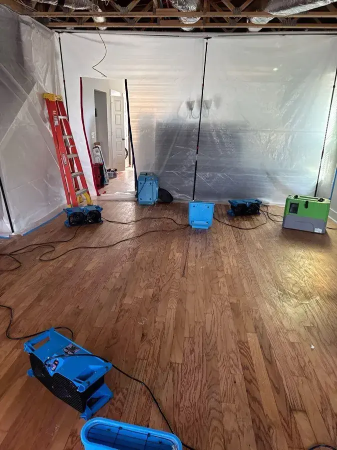 Crew removing wet flooring from a shop after storm water entered through the door